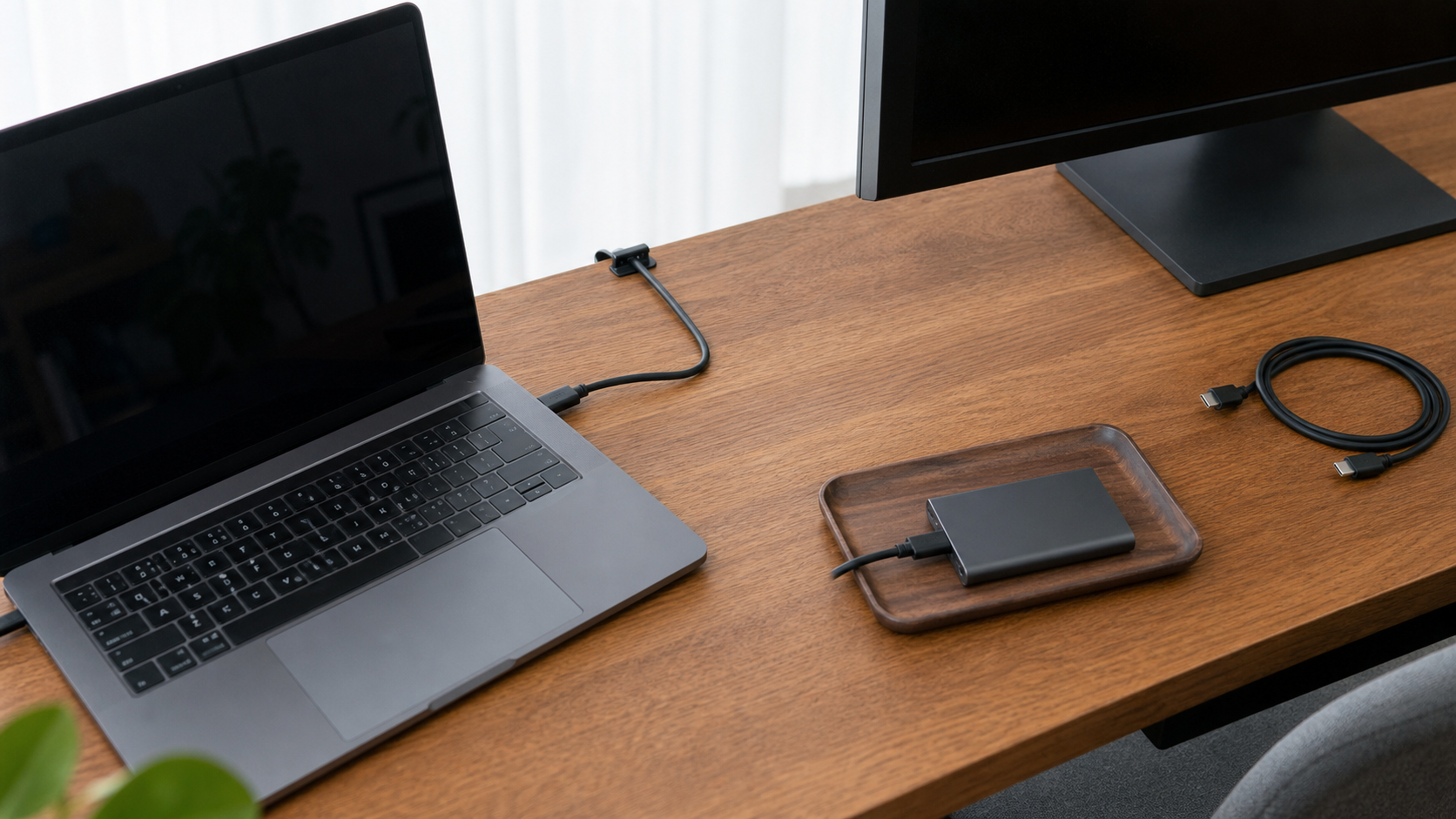 外付けSSDをトレーに置き短いUSB-Cケーブルを机奥へ通しているデスク