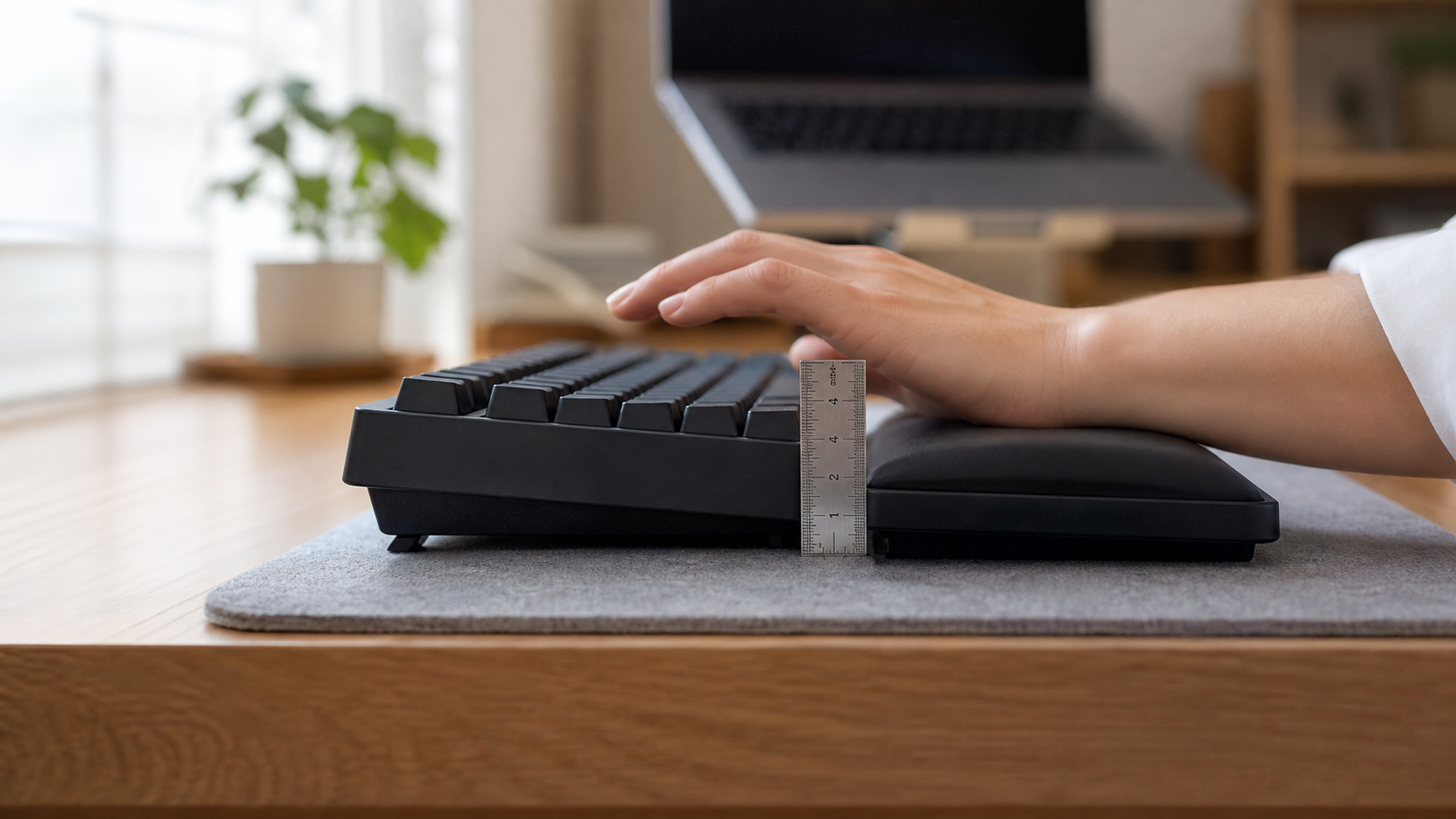 キーボードとパームレストの高さを定規で測っているデスク