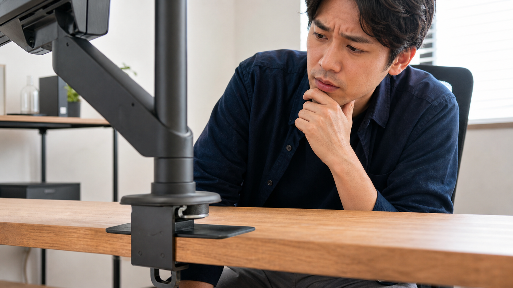モニターアームのクランプがデスク天板に当たり、傷や圧力が気になっている明るい作業机