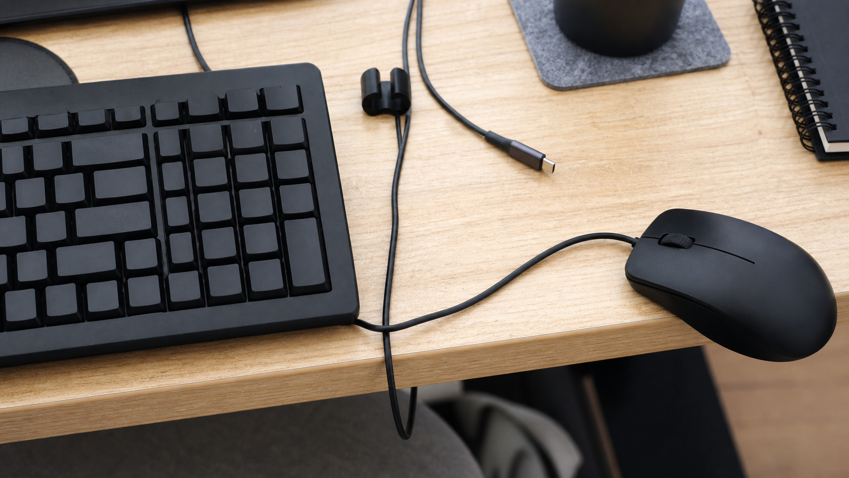 キーボードの角と机の端でマウスケーブルが曲がり引っかかっている様子