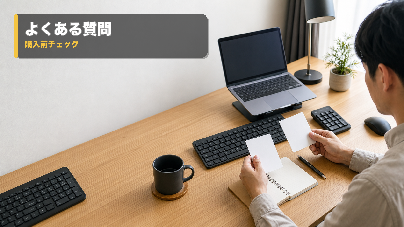 ノートPCとテンキーを前に、キーボード選びの疑問を確認している在宅ワーカー