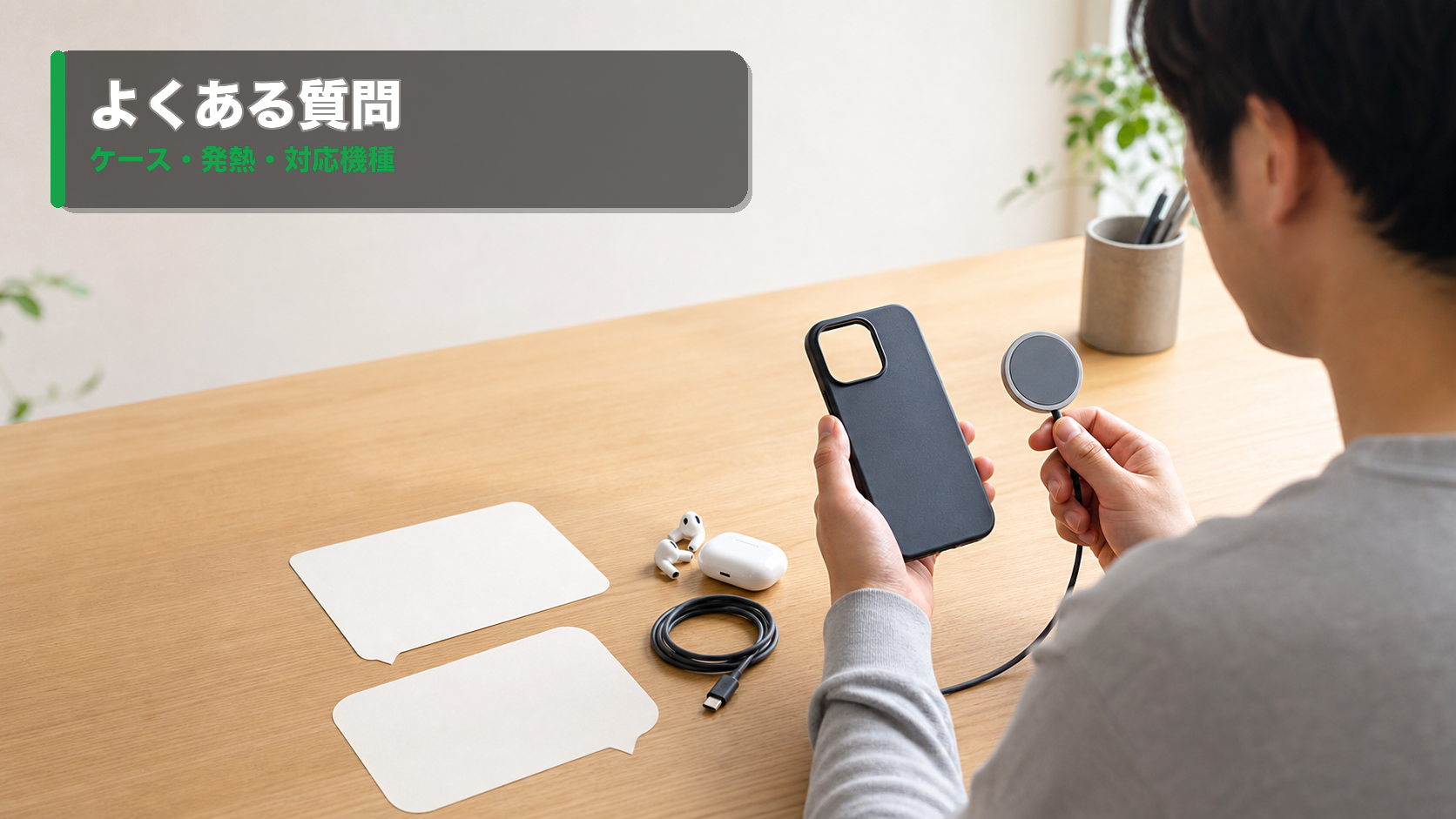 ワイヤレス充電器とスマホケースを前に、対応機種や発熱について質問しているホームオフィス