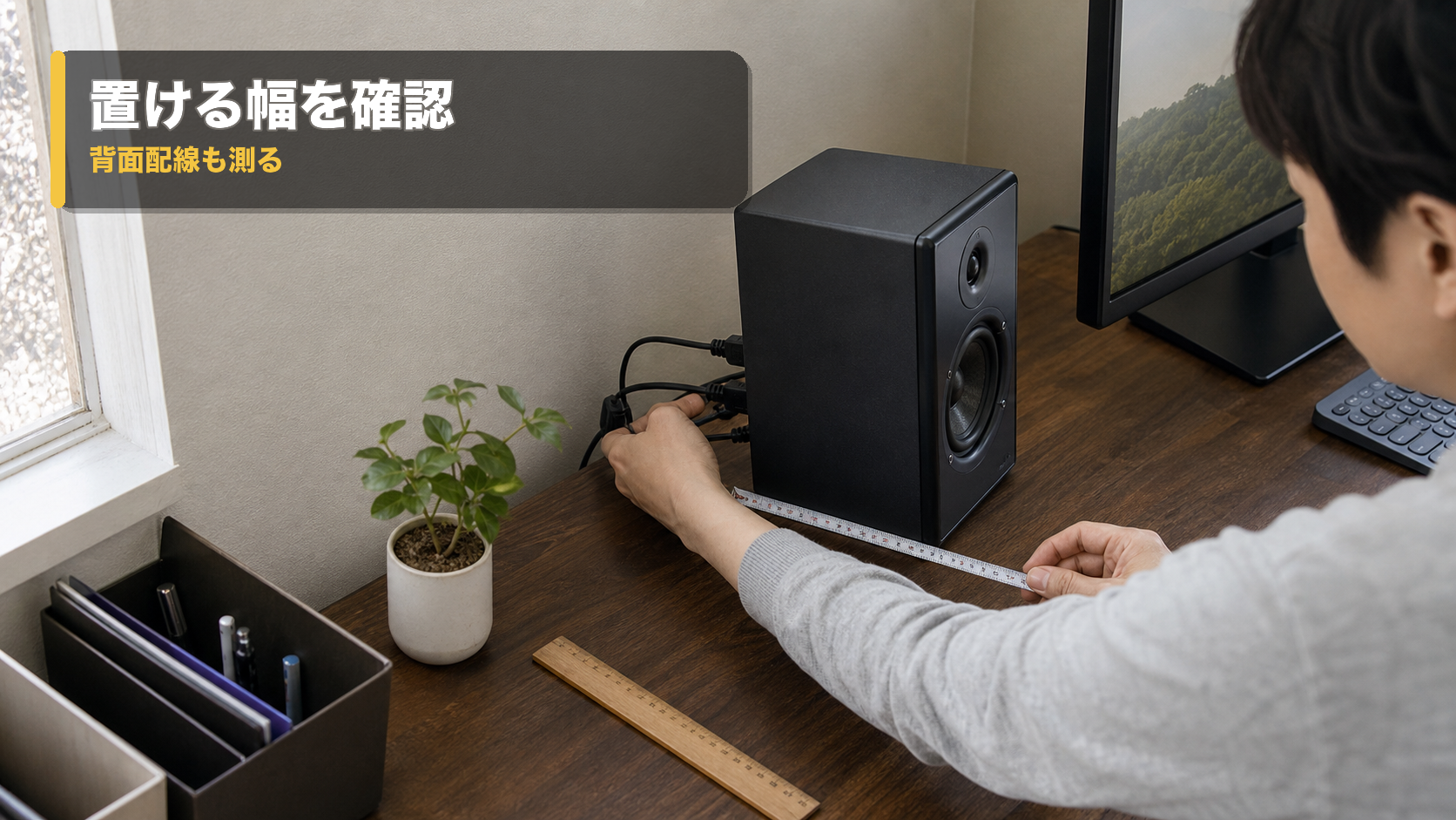 小型PCスピーカーの横幅と背面へ出るケーブルの余白をメジャーで確認する机上