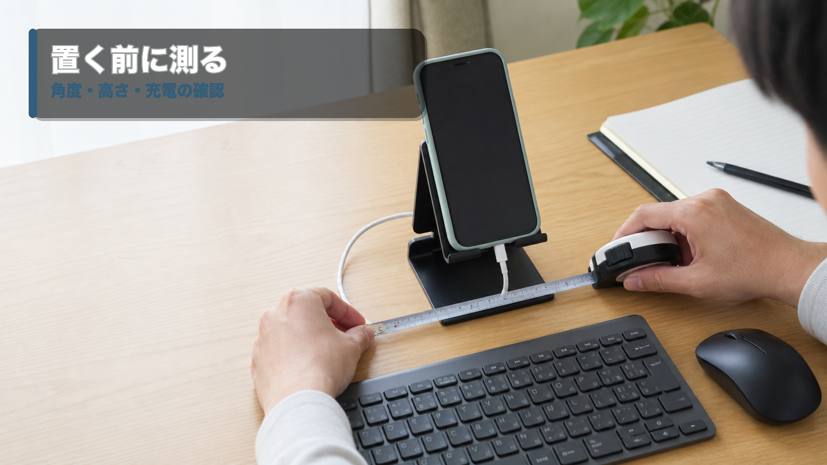 スマホスタンドの置く幅と充電ケーブルの出口をメジャーで確認するデスクの手元