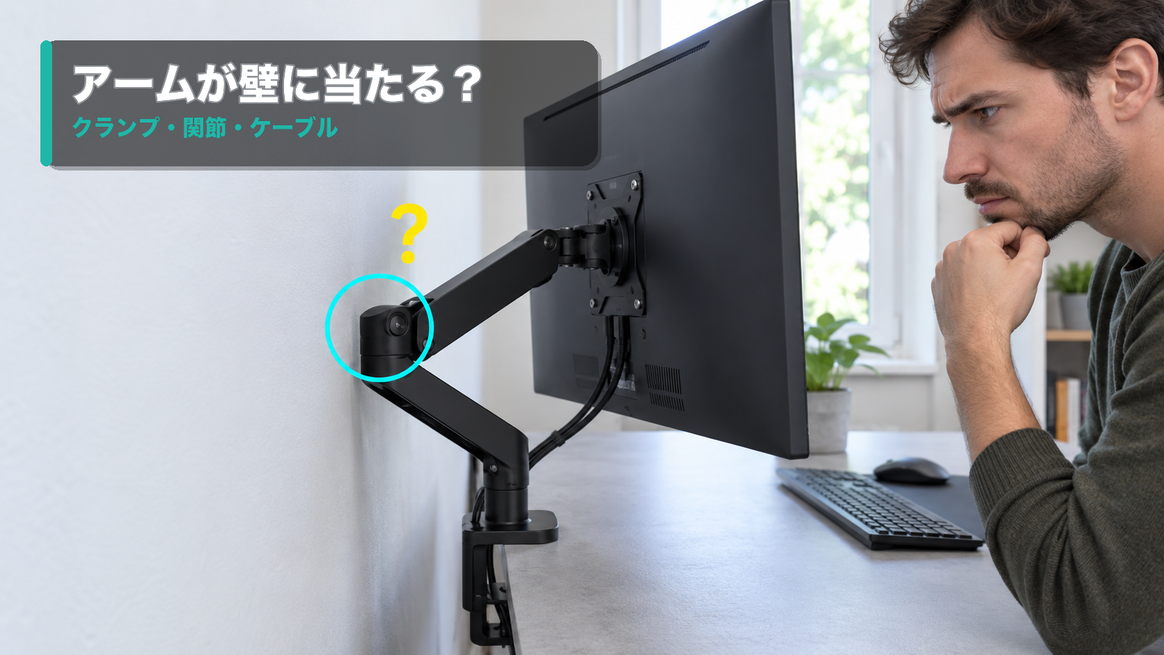 モニターアームの関節と壁の近さを確認する男性