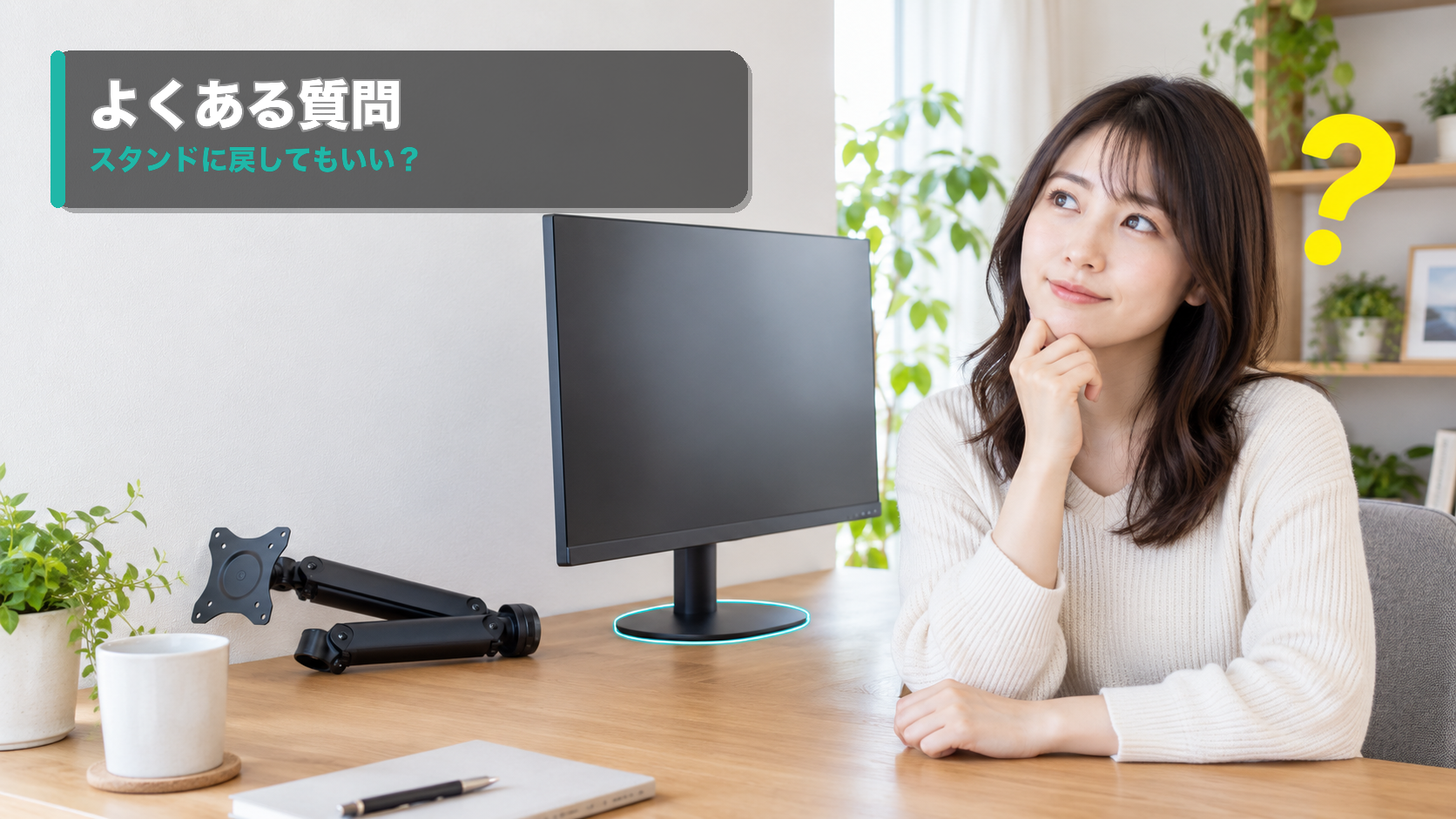 モニターの付属スタンドとアームを見て考える女性